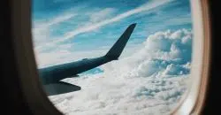 person taking picture of plane wings while flying during daytime